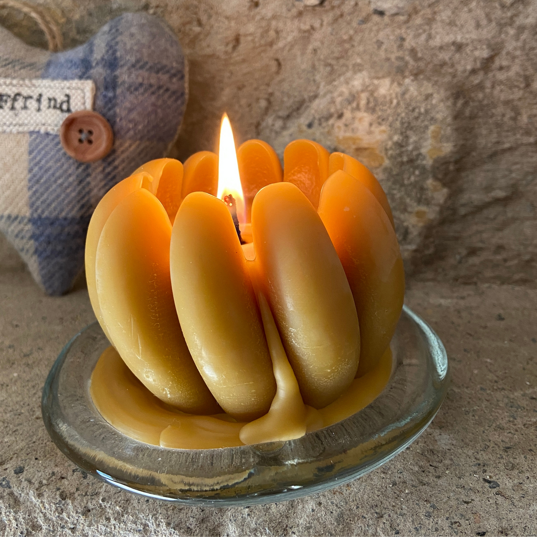 Lit handmade beeswax pumpkin candle with natural golden wax for autumn décor