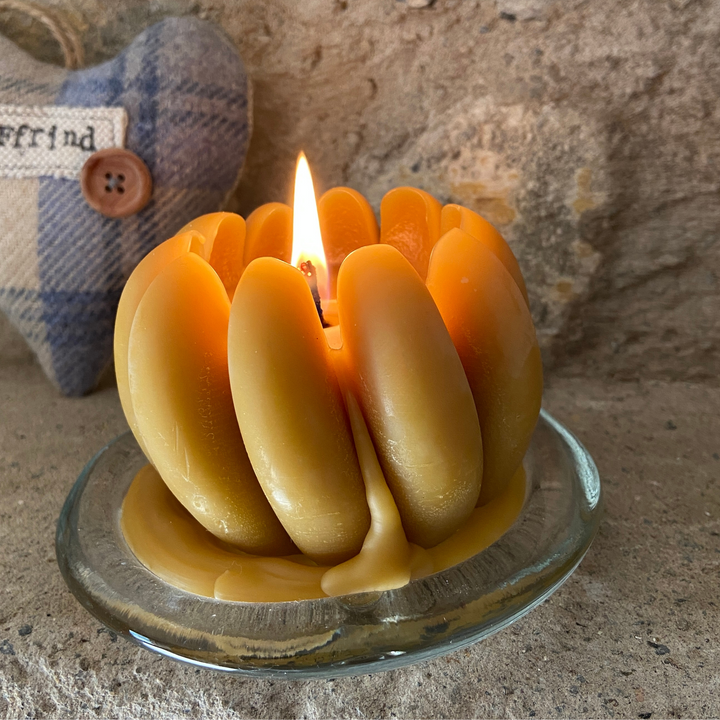 Lit handmade beeswax pumpkin candle with natural golden wax for autumn décor